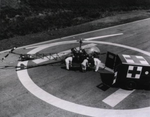 A litter patient being moved from a Bell H-13 Sioux helicopter