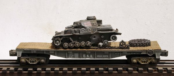 US Army WWII Captured Battle Damaged German PzIVF1 Tank, Turret No.135 on U.S. Army 40′ Flat Car USAX 23076(CAPAV1D.2-FC2.2USA/GER)_Operates on 3-Rail “O”Gauge track • Available Today • (CTN 17)