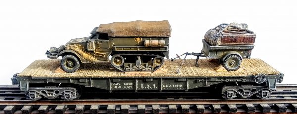 US Army M3 Half Track Troop Carrier w/Cover & Trailer Tow w/Supply Load on 40′ Flat Car U.S.A. 54610(AV9A.1-FC2.2USA)_Operates on 3-Rail “O”Gauge track  • Available Today • (CTN 26)