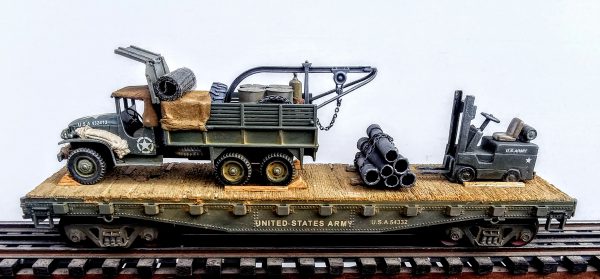 US Army GMC Cargo Truck w/Rescue Hoist & Fork Lift Truck Load on 42′ Flat Car w/Stacked Pipe Load, U.S.A. 54332(V8.2-FC3.2USA)_Operates on 3-Rail “O”Gauge track  • Available Today • (CTN 26)